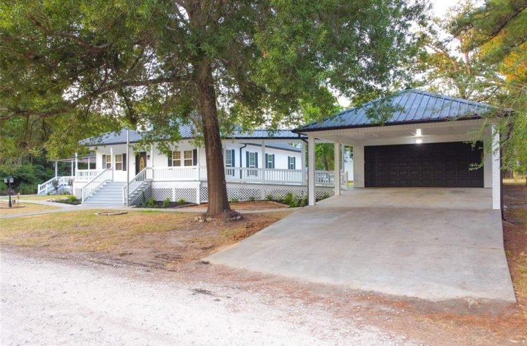 Oversized garage with double driveway and carport.